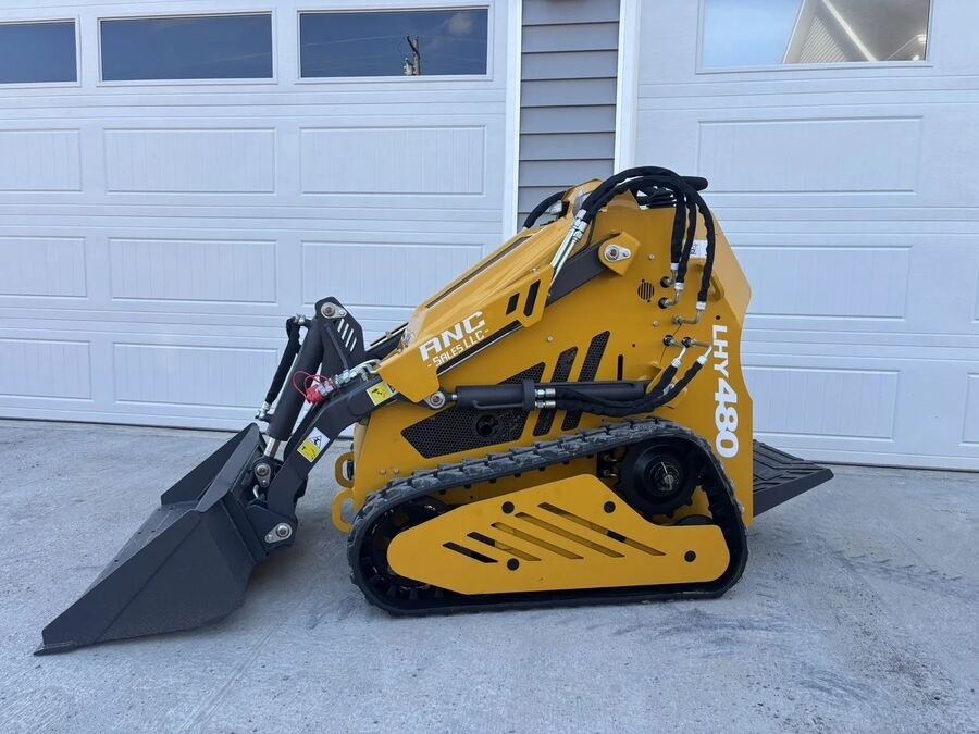 Orange Huayee LHY480 mini skid steer on rubber tracks with its bucket on the ground